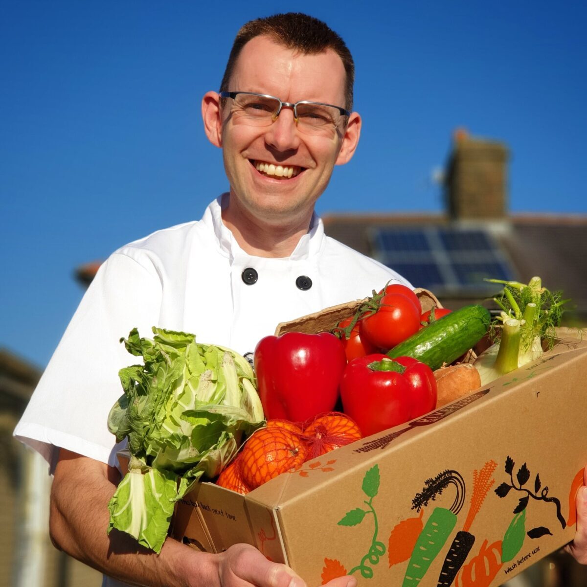 Shaun Nixon the cook in the north carrying a box of organic vegetables